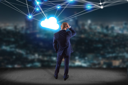View of a Businessman in front of a wall with a Cloud network with net and connection - Technology conceptの写真素材