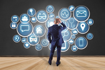 View of a Businessman in front of an interface of different mixed application - technology conceptの写真素材