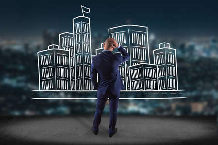 View of a Businessman in front of a wall with Hand drawn city center displayed on a futuristic interface - Travel conceptの写真素材