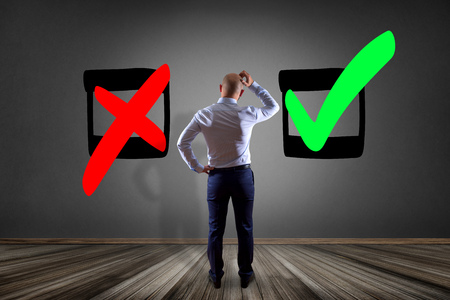 View of a Businessman in front of a wall looking for the good choice - business conceptの写真素材