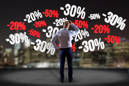 View of a Businessman in front of a wall with sales promotion 20% 30% and 50% flying on an interface - Shopping conceptの写真素材