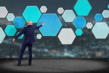 View of a Businessman in front of a wall with 3d render empty aplication made of blue hexa button 