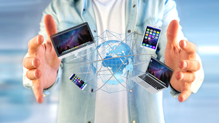 View of a Businessman holding a Computer and devices displayed on a futuristic interface with international network  - 3d renderの写真素材
