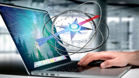 View of a Business man using a navigation compass on a laptop - 3d renderedの写真素材