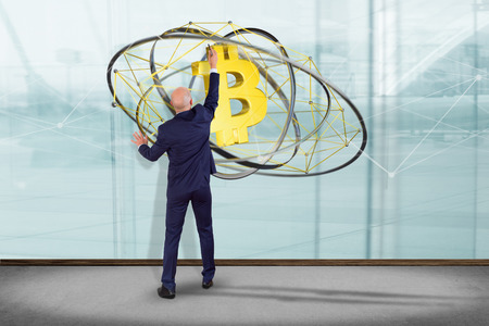 View of a Businessman in front of a wall with a Bitcoin crypto currency sign flying around a network connection - 3d renderの写真素材
