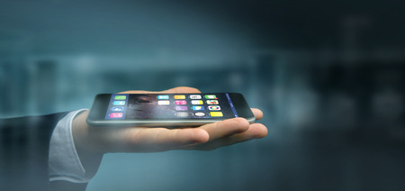 View of a Hands on the dark holding a smartphoneの写真素材