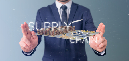 View of a Businessman holding a Supply Chain title with a warehouse on background 3d renderingの写真素材