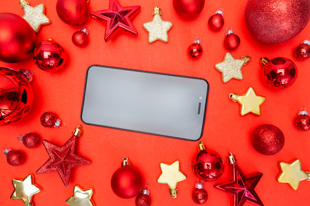 View of a Blank mock up smartphone on a red and white christmas decoration compositionの写真素材
