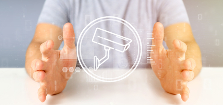 View of Businessman holding Security camera system icon and statistics data - 3d renderingの写真素材