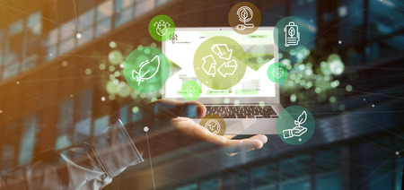 View of a Businessman holding a Cloud of green ecology icon bubble with a laptop 3d rendering