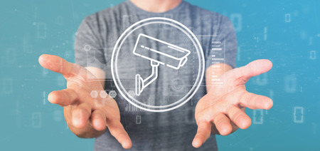 View of Businessman holding Security camera system icon and statistics data - 3d renderingの写真素材