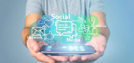 View of a Businessman holding a cloud of social media network iconの写真素材