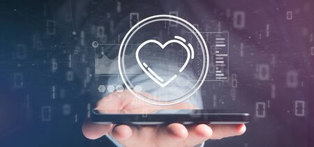 View of a Businessman holding a heart icon surrounded by dataの写真素材