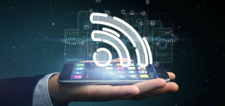 View of a Businessman holding a wifi icon with data all around