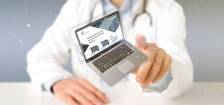 View of a Doctor holding a Laptop with business website template on the screen isolated on a backgroundの写真素材