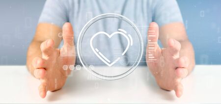 View of a Businessman holding a heart icon surrounded by dataの写真素材