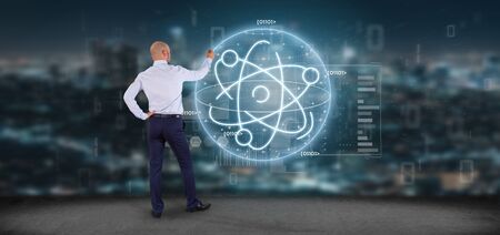 View of a Businessman holding an atom icon surrounded by dataの写真素材