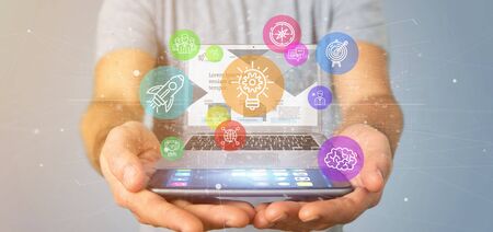 View of a Businessman holding a Cloud of colorfull start up icon bubble with a laptop 3d renderingの写真素材