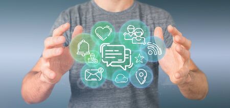 View of a Businessman holding a cloud of social media network iconの写真素材