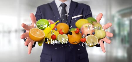 View of a Businessman holding Fruits and vitamins - 3d renderingの写真素材