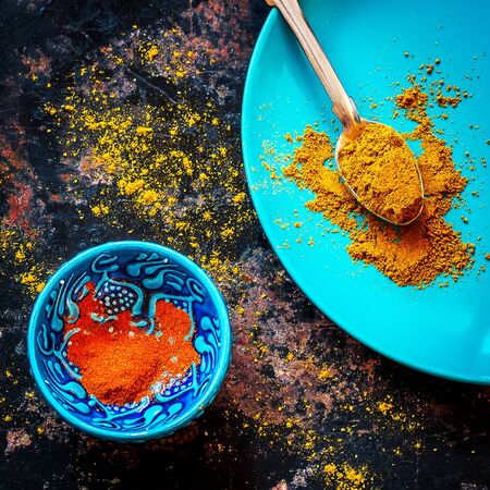 curry and red pepper on a blue plate, dark metal background.の写真素材