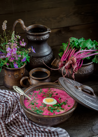 Russian cold soup with beetroot, bowl, spoons, greenery on dark wooden tableの写真素材
