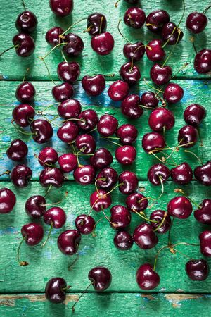 Cherry on old rustic painted cracky green (turqouise) wooden background.の写真素材