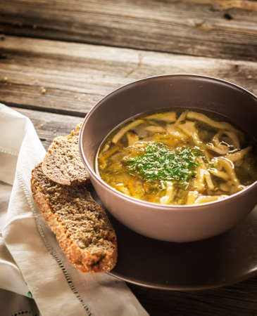 Bowl with  soup and napkin on wooden table. Style rustic.の写真素材