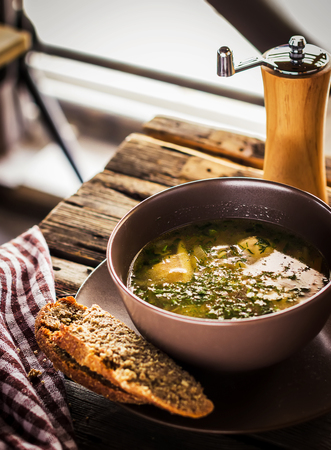 Bowl with  soup and napkin on wooden table. Style rustic.の写真素材