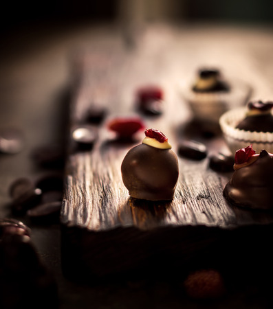 Chocolate sweets with dried berries and chocolate beans on dark background. Selective focus.の写真素材