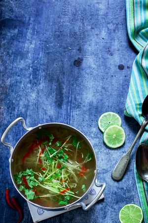 Chi?ken soup with vegetable marrow 
noodles in casserole. Blue background. Selective focus.の写真素材