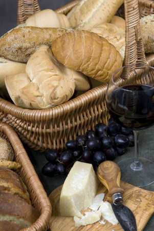 Assorted Breads and cheeses with a glass of wineの写真素材