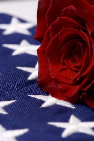 A lone red rose lying on top of a folded American flag. My hero.の写真素材