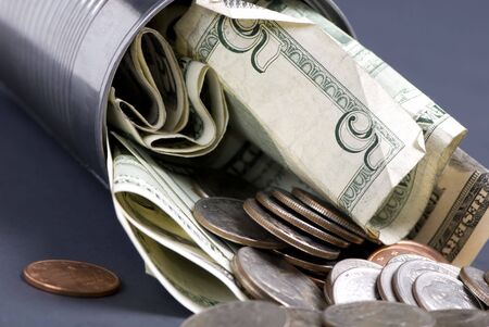 A small tin can is suffed with money... somebodys secure savingsの写真素材
