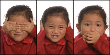 A young girls plays out See NO Evil, Hear no Evil, and Speak no Evilの写真素材