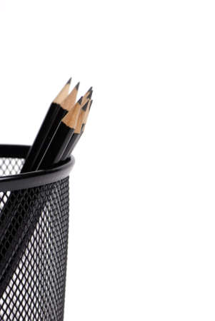 A group of black lead pencils in a container on a desktopの写真素材