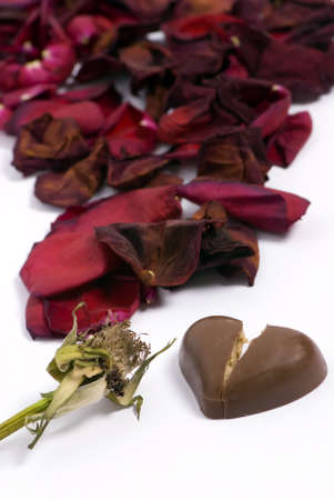 A withered red rose with a small heart chocolate.... broken. Lost loveの写真素材