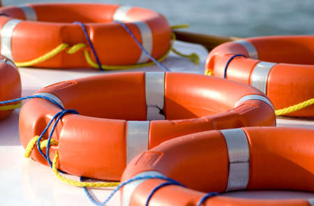 Bright orange life rings lay on top of a boat. safety, danger, rescue, security