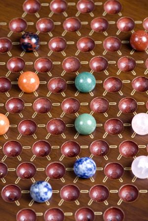 A macro shot of a chinese checker board with colorful marbles