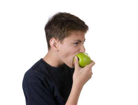 A young boy eating an apple.  Isolated on white.の写真素材