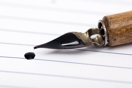 An old book that is open with a calligraphy pen on top.の写真素材