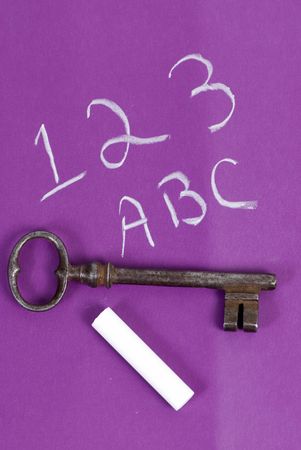 An old key sits on top of a childs chaulk board. unlocking the pastの写真素材