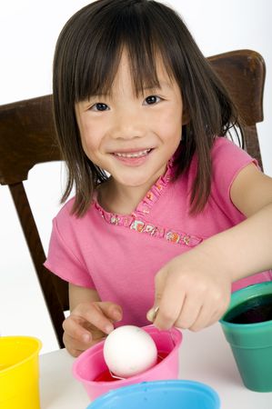 a young Asian girl coloring Easter Eggs.の写真素材