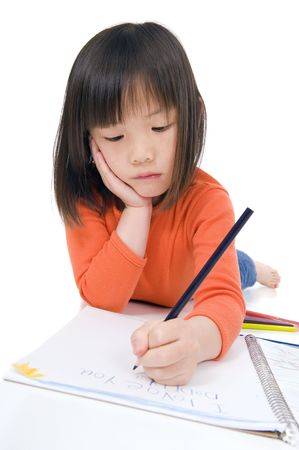 A young asian girl drawing a picture. On whiteの写真素材