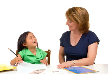 A young girl learns to write with the help of a teacher.の写真素材