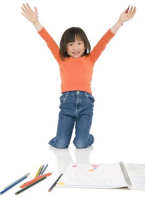 A young asian girl drawing a picture. On whiteの写真素材