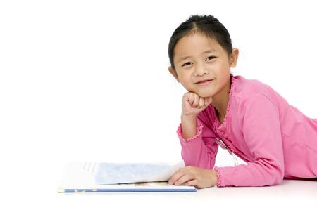 A young asian girl reading a book. On whiteの写真素材