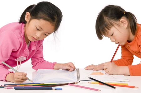 A young asian girl drawing a picture. On whiteの写真素材