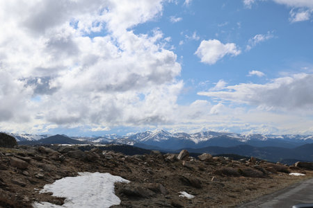 Mountain landscape with snow-capped peaks and blue cloudy skyの写真素材
