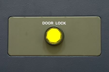 Steel plain surface with yellow button door lock